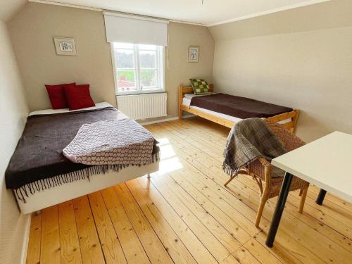a bedroom with two beds and a table in it at Holiday home KARLSKRONA IV in Karlskrona