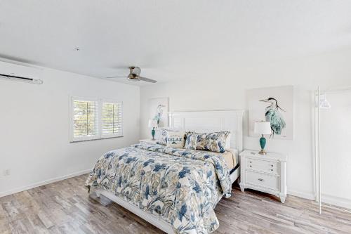 a white bedroom with a bed and a window at Tarpon Breeze in Marathon