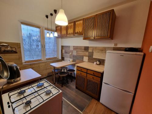a kitchen with a white refrigerator and a table at Komfortowy Apartament blisko plaży in Gdańsk
