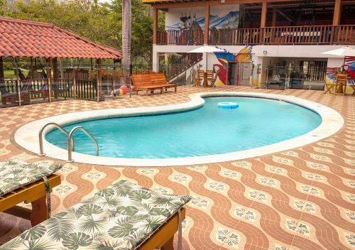 a swimming pool in a patio with a table and chairs at Senderos del Mar - Tayrona in Buritaca
