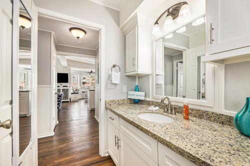 La salle de bains blanche est pourvue d'un lavabo et d'un miroir. dans l'établissement Sailboat House, à Surfside Beach
