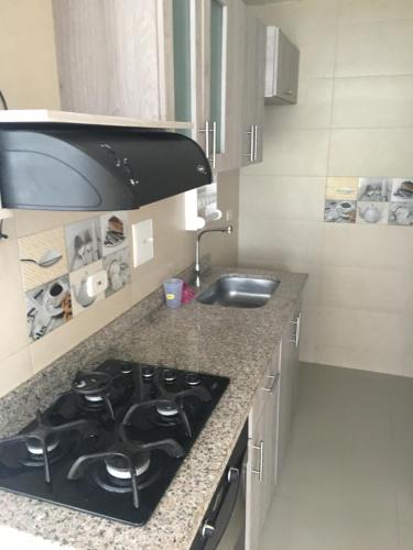 una cucina con piano cottura e lavandino di Apartamento villavicencio a Villavicencio
