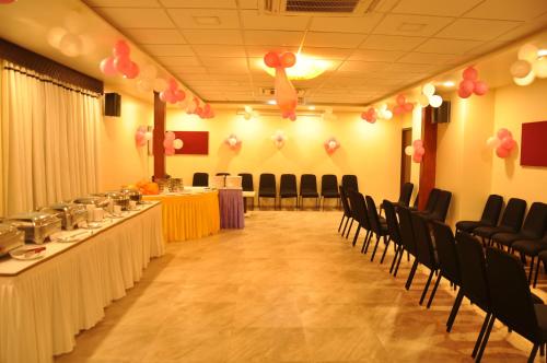 a banquet hall with chairs and tables and pink balloons at Hotel Green Olive in Aurangabad