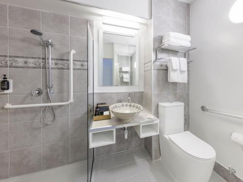 a bathroom with a toilet and a sink and a shower at JetPark Auckland Airport Hotel in Auckland