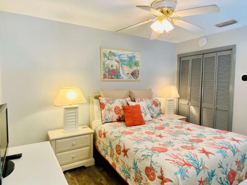 a bedroom with a bed and two lamps and a ceiling fan at Grand Caribbean 419 by ALBVR - New Owner - Great location in Orange Beach