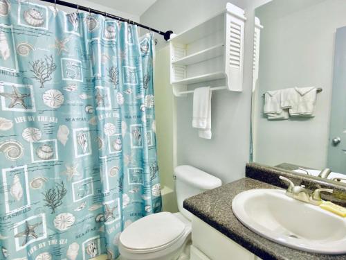 a bathroom with a sink and a toilet and a shower curtain at Grand Caribbean 419 by ALBVR - New Owner - Great location in Orange Beach