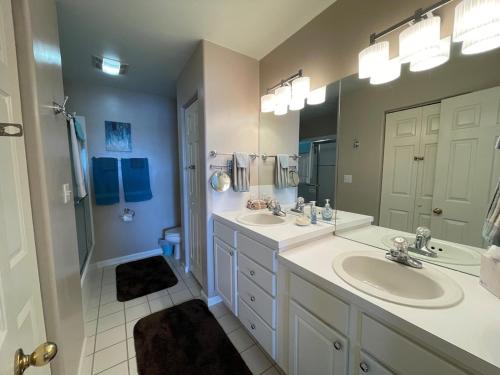 a bathroom with two sinks and a large mirror at Rare GEM @Emerald Bay - Smart Home - THAT VIEW!!! in Lake Ozark