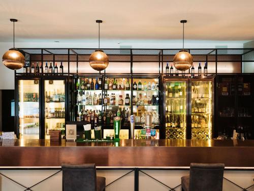 a bar with a lot of bottles of alcohol at JetPark Auckland Airport Hotel in Auckland