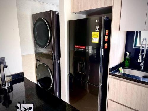 a kitchen with a microwave and a refrigerator and a sink at Descanso y Confort 3 Luxury in La Tebaida
