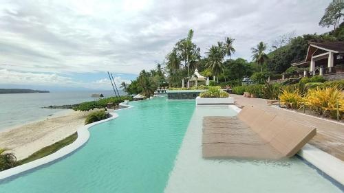 een zwembad met blauw water naast een strand bij Kembali CONDO Resort with Sea View in Davao City