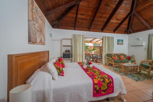 um quarto com uma cama e uma sala de estar em The Cooks Oasis em Rarotonga