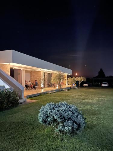 une maison avec une pelouse devant elle la nuit dans l'établissement Sereno Village, à Ulcinj