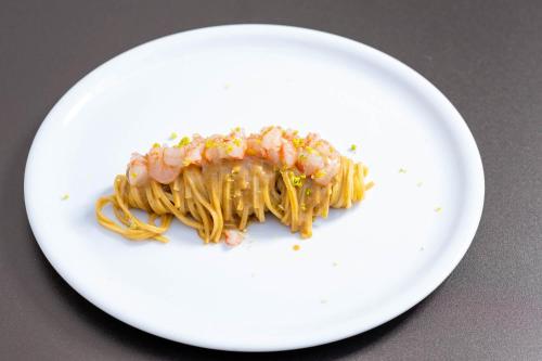 a white plate with shrimp and pasta on it at Palazzo Tafuri Boutique Hotel in Nardò