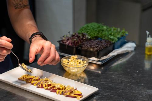a person is eating food on a plate with a spoon at Palazzo Tafuri Boutique Hotel in Nardò
