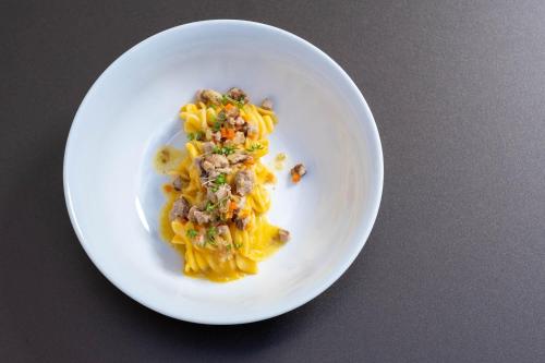a white plate with pasta with meat and cheese at Palazzo Tafuri Boutique Hotel in Nardò