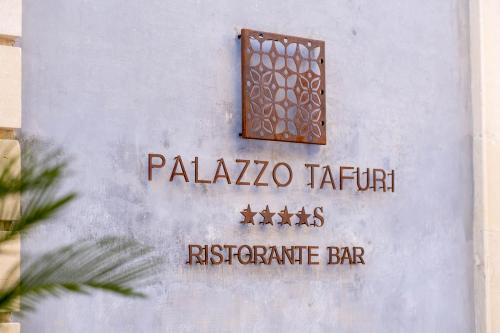 a sign on the side of a building with a window at Palazzo Tafuri Boutique Hotel in Nardò