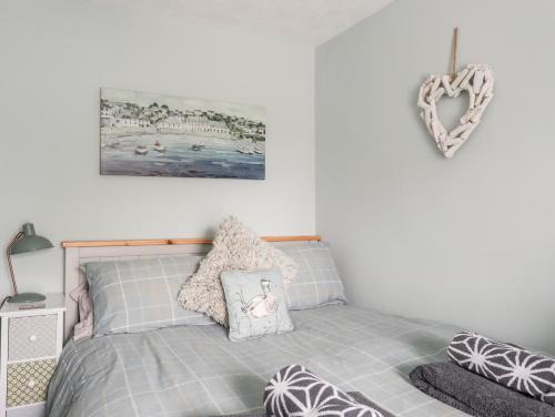 a bedroom with a bed with pillows on it at Bryn Peris in Moelfre