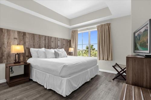 een slaapkamer met een groot wit bed en een raam bij The Point, Lux Apartment 4 min from Universal in Orlando