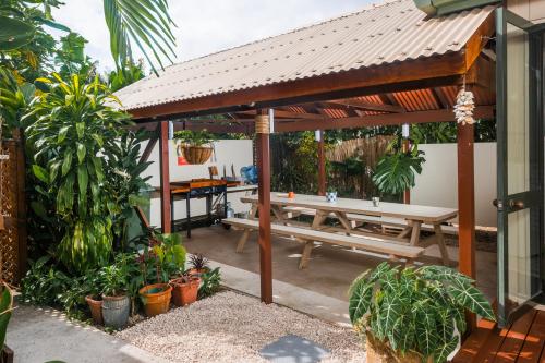 a wooden pergola with a picnic table on a patio at The Cooks Oasis in Rarotonga