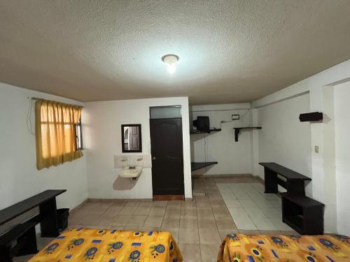 Cette chambre comprend 2 lits et un lavabo. dans l'établissement Hotel Jorges Morelia, à Morelia
