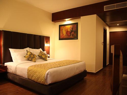 a bedroom with a large bed in a room at Hotel Cama in Chandīgarh