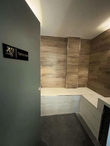 y baño con ducha y paredes de madera. en Apartamento moderno, en Colonia Mariano Roque Alonso