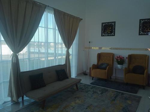 a living room with two chairs and a couch and windows at MY KIJANG HOMESTAY - Banglo, Alor Setar Kedah DarulAman in Alor Setar