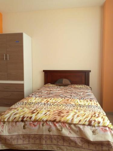 una camera con un letto dotato di cassettiera e copriletto di Sun Habitacion Privada a Riobamba