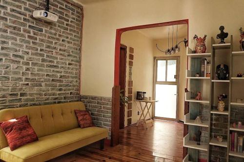 a living room with a couch and a brick wall at El rincón de la Escandón in Mexico City