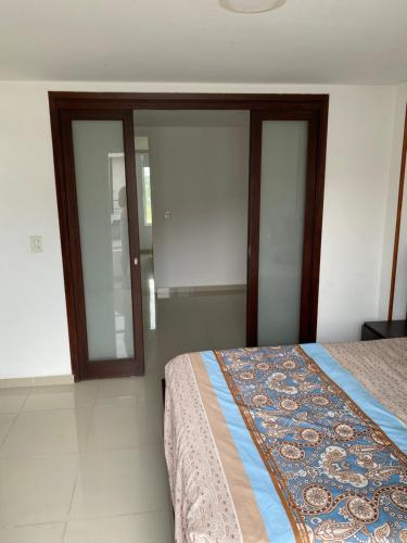 een slaapkamer met een bed en glazen schuifdeuren bij Casa en Villavicencio buena ubicación in Villavicencio