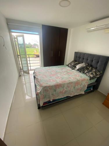 een slaapkamer met een bed en een glazen schuifdeur bij Casa en Villavicencio buena ubicación in Villavicencio