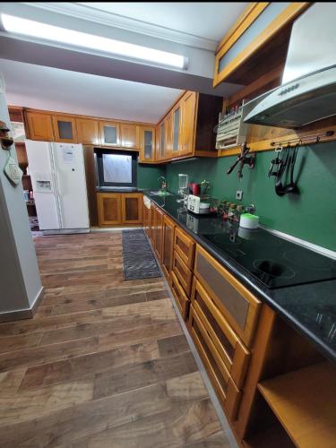 a kitchen with wooden cabinets and a black counter top at Casa Cabanas piscina água quente in Viana do Castelo