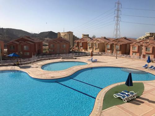 a swimming pool with two chairs in a resort at Porto sokhna in Ain Sokhna