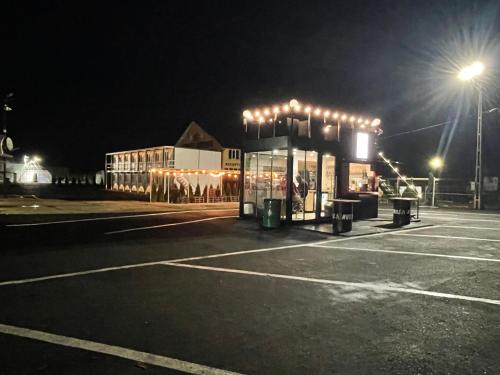 a parking lot with a bus stop at night at Spatii cazare modulare muncitori in Tupilaţi