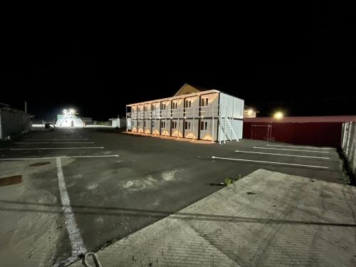 een lege parkeerplaats met een gebouw 's nachts bij Spatii cazare modulare muncitori in Tupilaţi