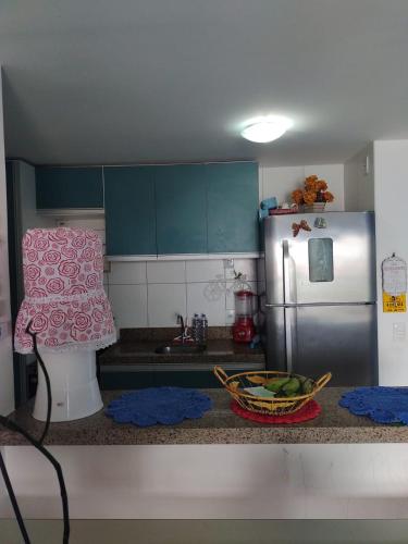 a kitchen with a refrigerator and a bowl of vegetables on the counter at Quarto 2 pessoas São Gerardo in Fortaleza