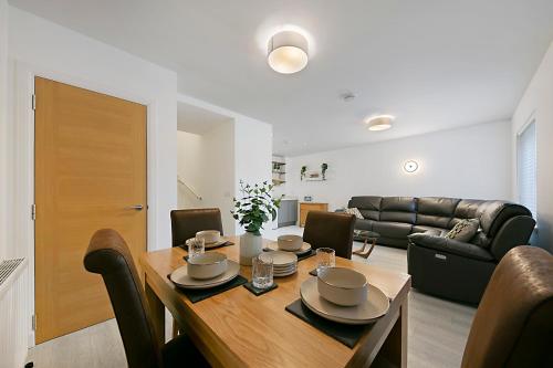 una sala da pranzo con tavolo e divano di Maidencraig Court House ✪ Grampian Lettings Ltd ad Aberdeen