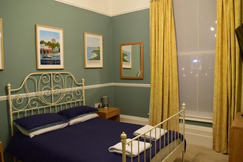 a bedroom with a bed with a blue bedspread at The Portland Hotel in Folkestone