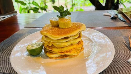 a stack of pancakes on a plate on a table at Phong Nha Mountain House in Vực Trô