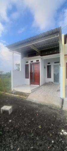 a white house with red doors and a driveway at Alvaiz home in Gunungsan