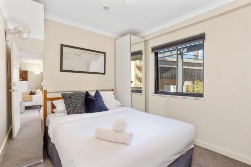 een slaapkamer met een wit bed en een raam bij Executive 2br Suite On Mounts Bay Road in Perth