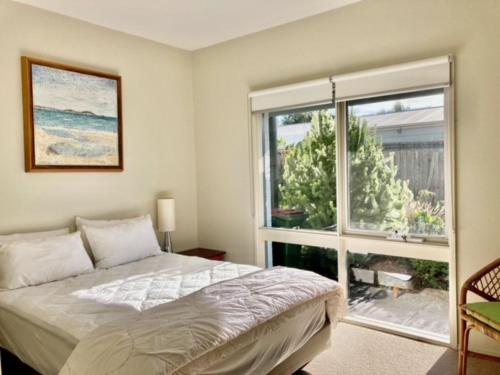 a bedroom with a bed and a large window at Glan Mor in Queenscliff