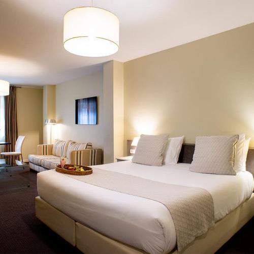 a large white bed in a hotel room at Ikonik Plaza Mercado in Salamanca