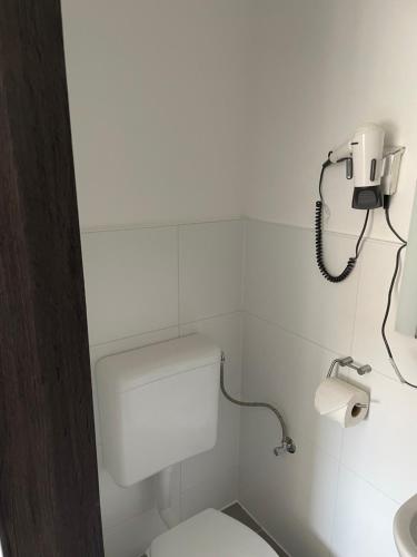 a bathroom with a toilet and a phone on the wall at Pension Wob in Wolfsburg