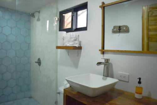 a bathroom with a white sink and a mirror at Blue Window Boutique Villas Hotel in Playa Junquillal