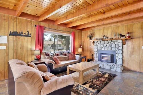 ein Wohnzimmer mit einem Sofa und einem Kamin in der Unterkunft The Getaway Cabin in Big Bear City