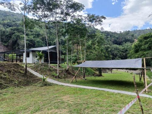 a house in the middle of a field with a tent at Kuriou Lodge & Campsite in Kiulu