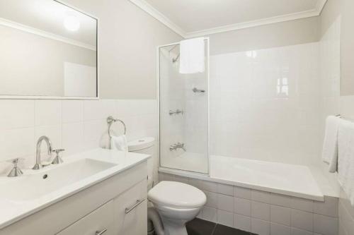 La salle de bains blanche est pourvue de toilettes et d'un lavabo. dans l'établissement Ideal 1BR Suite near the Manly Beach with Pool, à Sydney