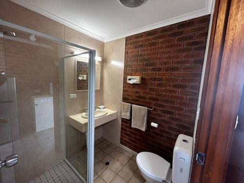 a bathroom with a toilet and a sink and a shower at Balranald Colony Inn Motel in Balranald