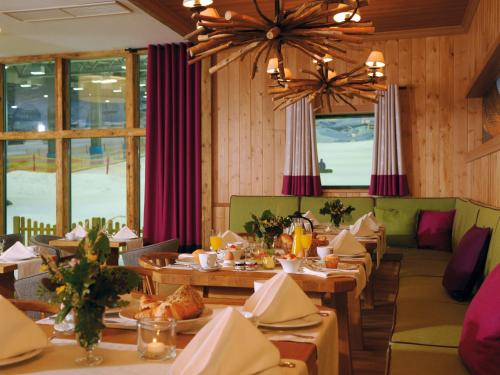 a dining room with tables and chairs and windows at Hotel Fire & Ice Düsseldorf/Neuss in Neuss